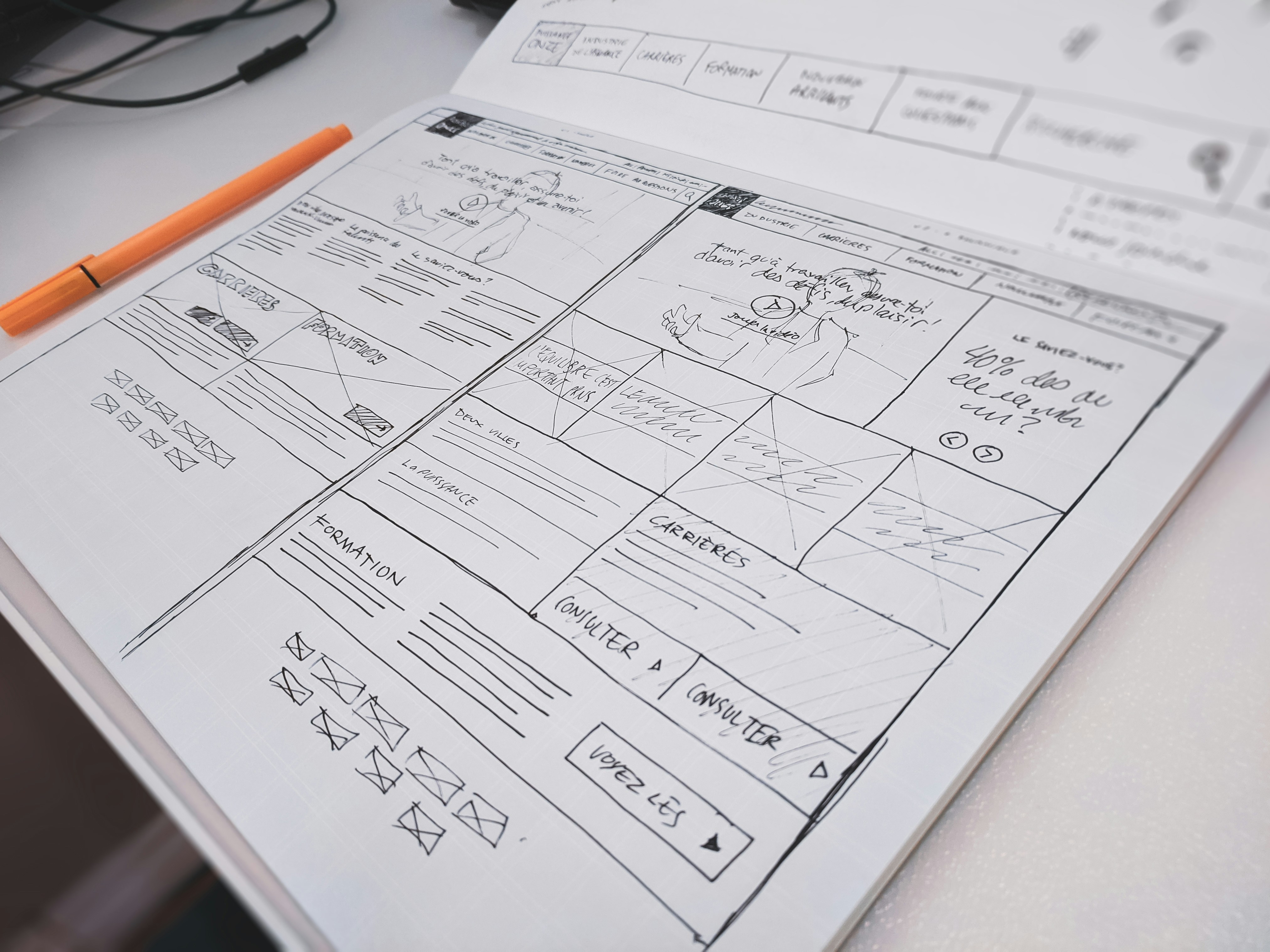 Designer sketching wireframes with a pen at a desk
